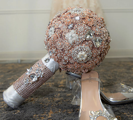 10inch Rosegold Brooch Bouquet, Blinged Bouquet, Handmade. This alluring rosegold brooch bouquet combines a variety of dazzling, crystal rhinestones for a one of a kind look. To complete the look, a satin bow was added to this glamorous bouquet and the handle was wrapped in satin. It's perfect for any bride and will be a lasting keepsake on that special day.